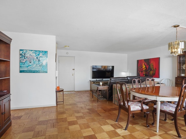 dining room featuring a chandelier and baseboards