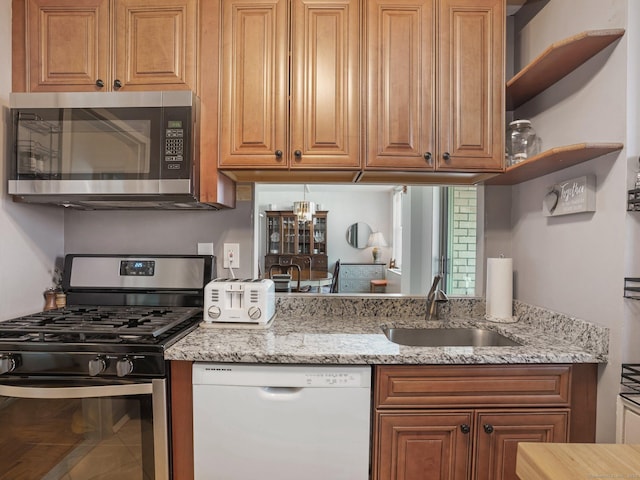 kitchen featuring light stone countertops, brown cabinetry, stainless steel appliances, and a sink