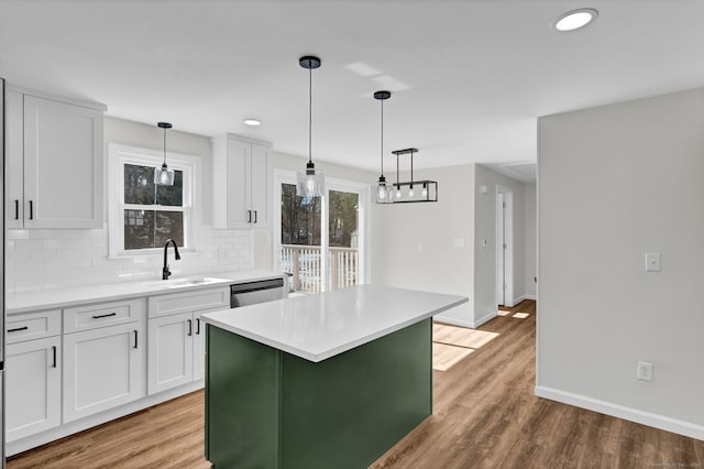 kitchen featuring stainless steel dishwasher, white cabinetry, decorative backsplash, and a sink