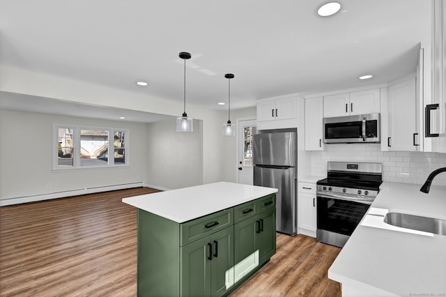 kitchen with white cabinets, stainless steel appliances, green cabinets, and a sink