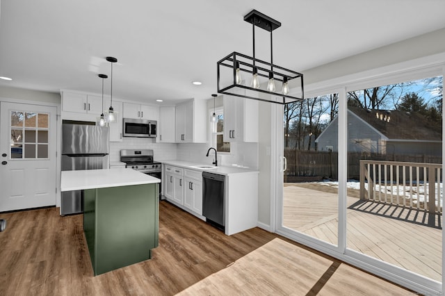 kitchen with dark wood-style flooring, stainless steel appliances, a sink, and light countertops