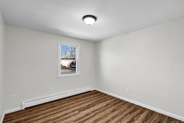 spare room featuring baseboards, baseboard heating, and wood finished floors