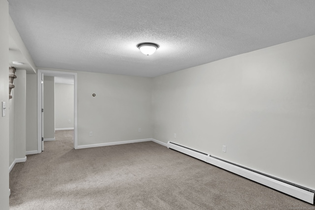 carpeted empty room featuring baseboards, a textured ceiling, and baseboard heating