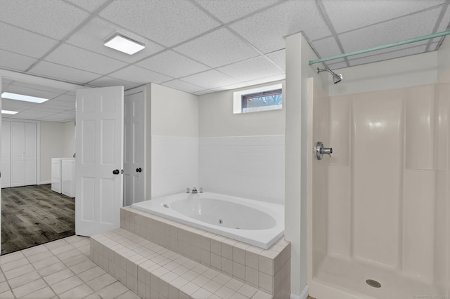 bathroom with tile patterned floors, a whirlpool tub, washing machine and clothes dryer, a paneled ceiling, and a shower stall