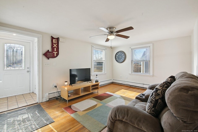 living area with a baseboard heating unit, ceiling fan, and wood finished floors