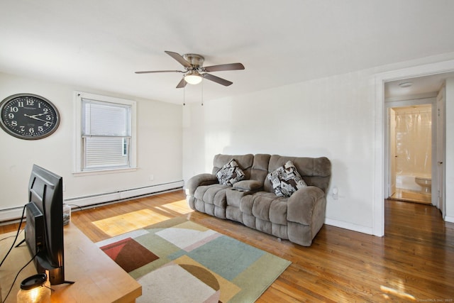 living area featuring baseboards, a ceiling fan, baseboard heating, and wood finished floors