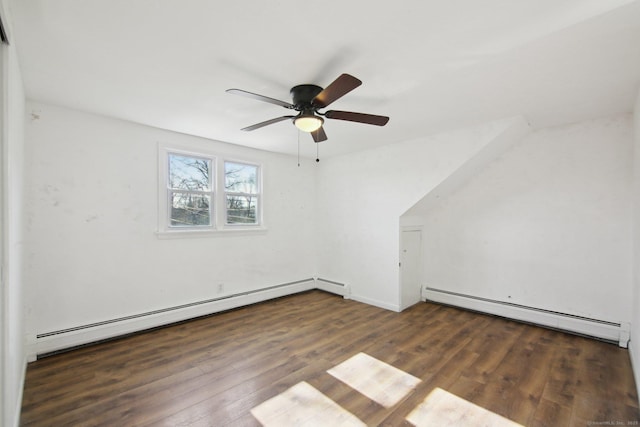 interior space with dark wood-style floors, a baseboard heating unit, and a ceiling fan