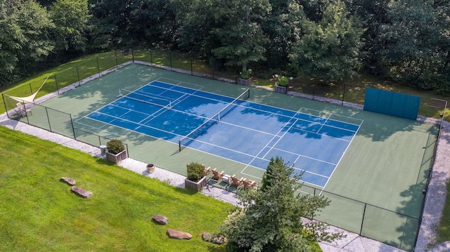 view of sport court with a yard and fence