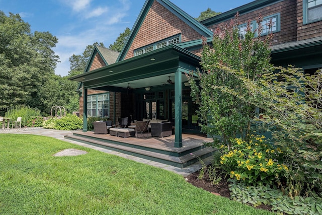 rear view of house featuring ceiling fan and a yard