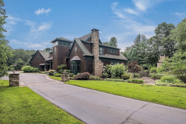 view of front of house featuring a chimney and a front yard