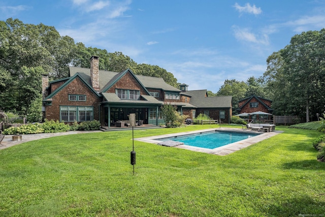 outdoor pool with fence and a yard