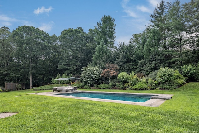 pool featuring outdoor lounge area, a patio, and a yard