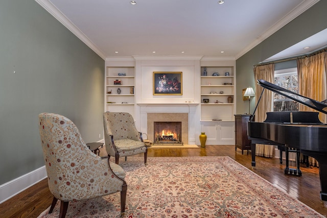 living area with ornamental molding, wood finished floors, a high end fireplace, and baseboards