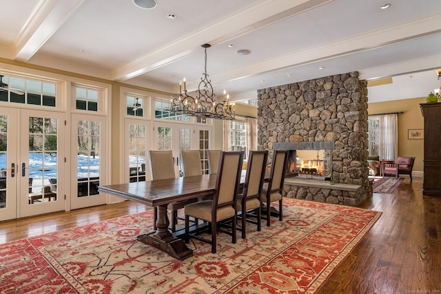 dining space with french doors, a fireplace, hardwood / wood-style floors, beamed ceiling, and baseboards