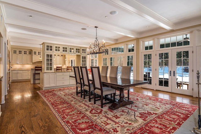 dining room with ornamental molding, dark wood-type flooring, an inviting chandelier, french doors, and beam ceiling