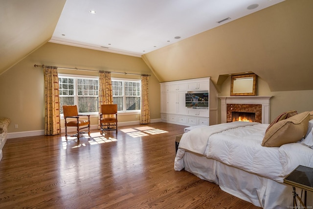 bedroom with lofted ceiling, baseboards, visible vents, and wood finished floors