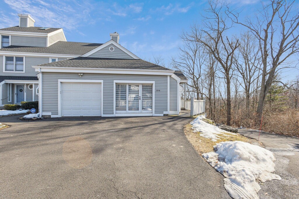 233 Mansfield Grove Rd Unit 106, East Haven, CT 06512 - view of property exterior featuring roof with shingles, a garage, driveway, and a chimney