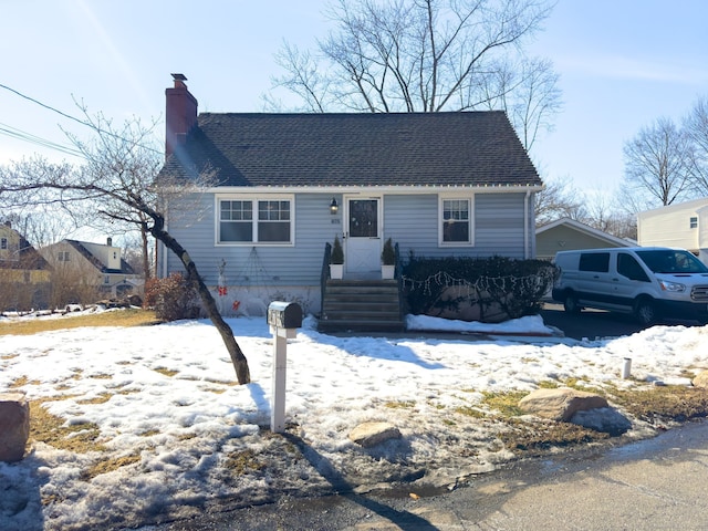 view of front of property with a chimney and roof with shingles