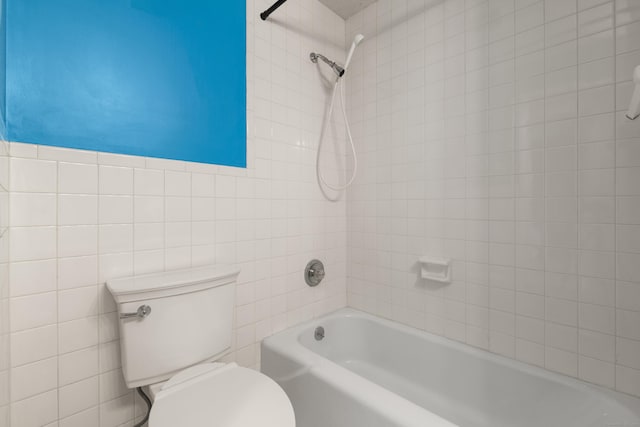 full bathroom featuring toilet, shower / bath combination, and tile walls