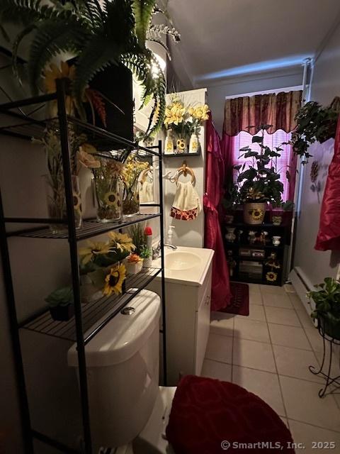 bathroom with toilet, tile patterned flooring, and vanity