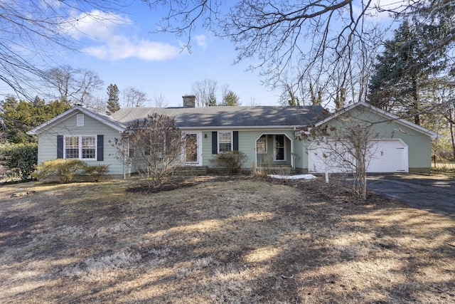 ranch-style house with driveway, a chimney, and an attached garage