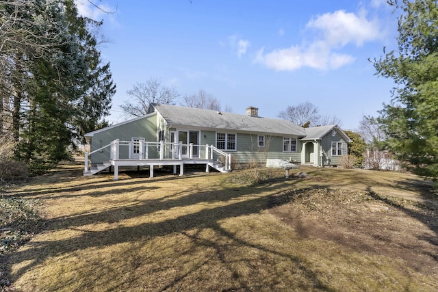 back of property featuring a chimney and a deck