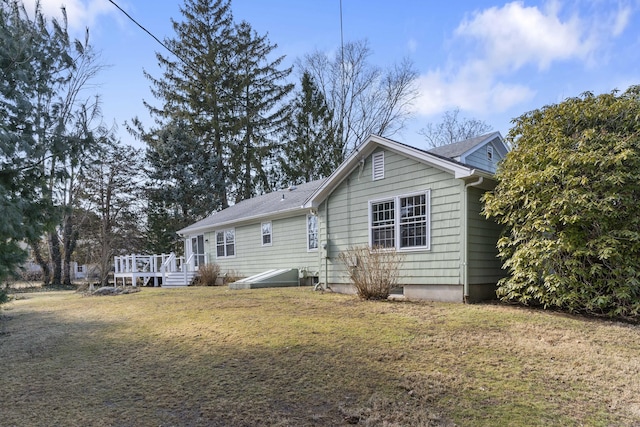 back of property featuring a wooden deck and a yard