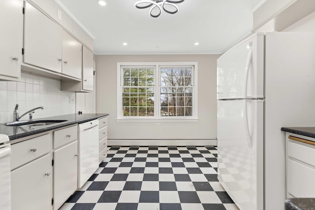 kitchen featuring white appliances, a baseboard radiator, dark floors, crown molding, and a sink