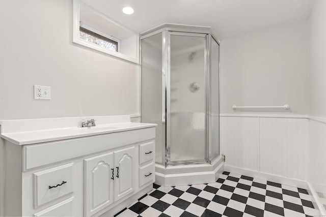 bathroom featuring a stall shower, wainscoting, vanity, and tile patterned floors