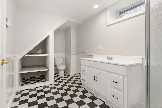 bathroom with a baseboard heating unit, vanity, toilet, and tile patterned floors