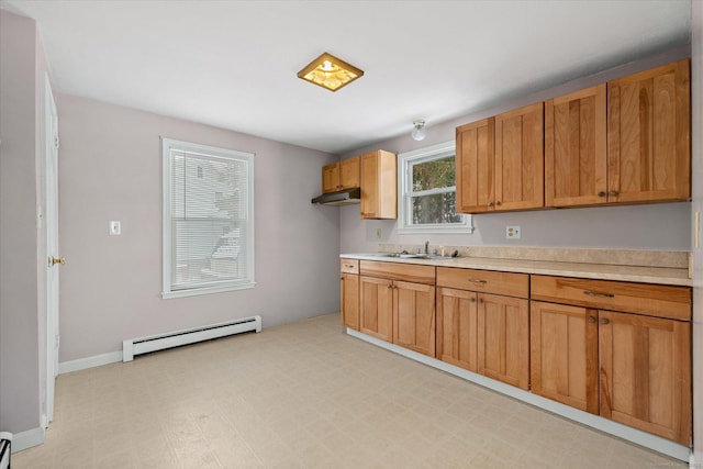 kitchen featuring a sink, light floors, baseboard heating, and light countertops