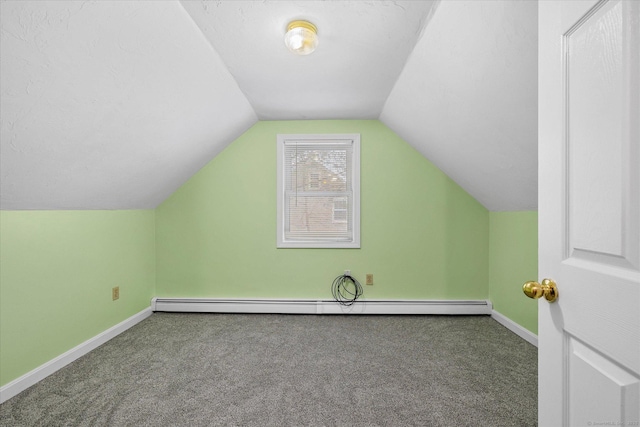 additional living space with carpet, a baseboard heating unit, vaulted ceiling, and baseboards