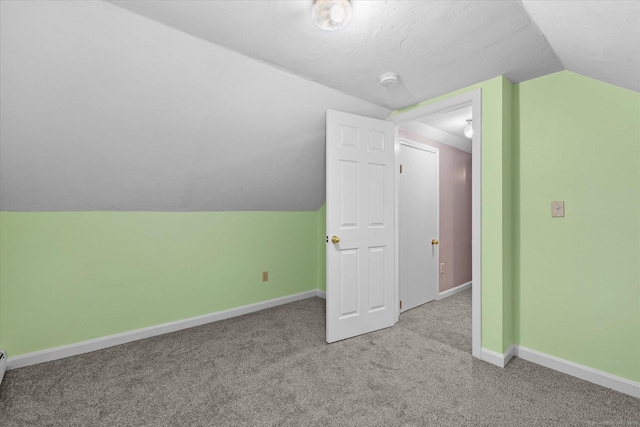 bonus room featuring light carpet, lofted ceiling, and baseboards