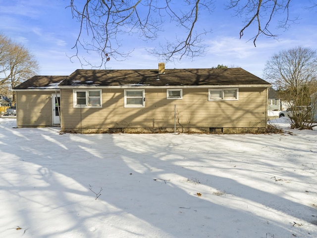 snow covered property with a chimney