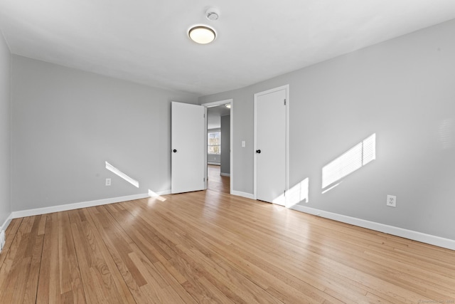 unfurnished room with light wood-style floors and baseboards