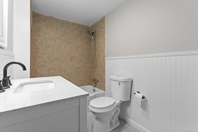 full bath featuring toilet, shower / bath combination, vanity, wainscoting, and tile patterned floors