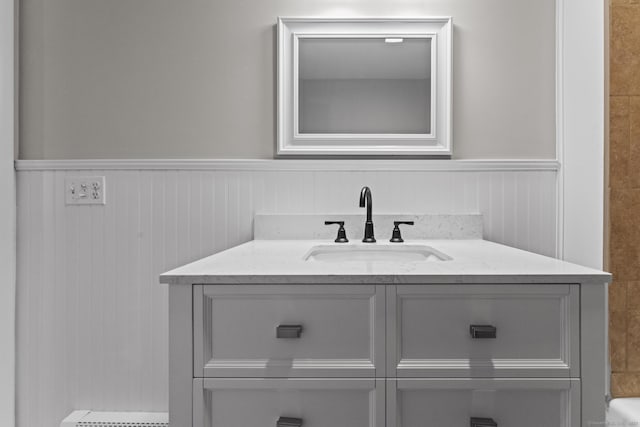 bathroom with a wainscoted wall and vanity