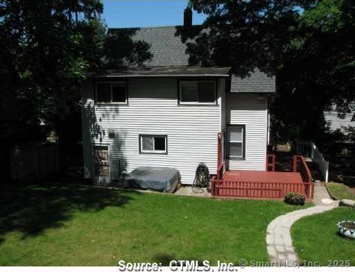 rear view of property with a lawn and a wooden deck