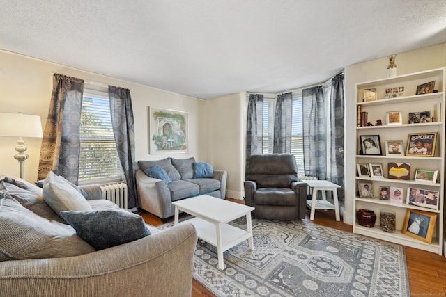 living room with a textured ceiling, wood finished floors, and radiator