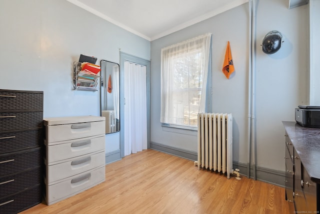 interior space with light wood-style floors, radiator, and ornamental molding