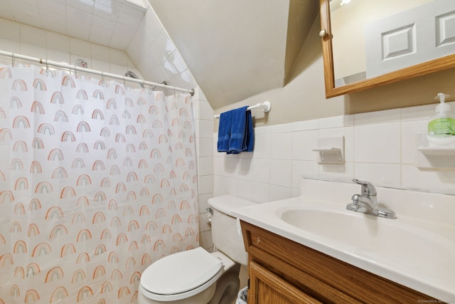 bathroom featuring lofted ceiling, curtained shower, toilet, vanity, and tile walls