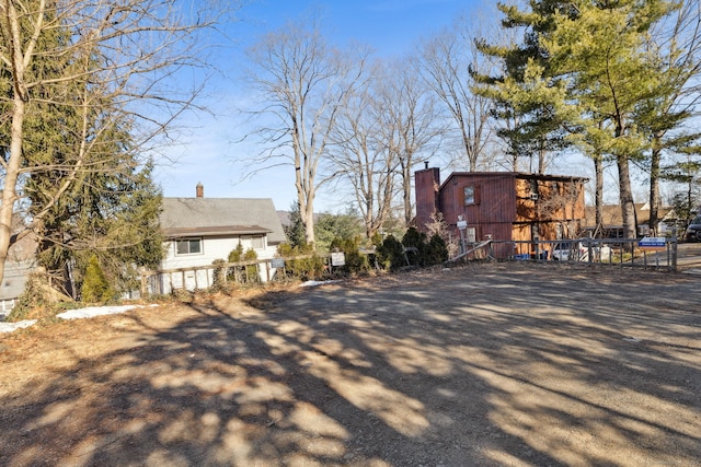 view of side of property with a chimney and fence