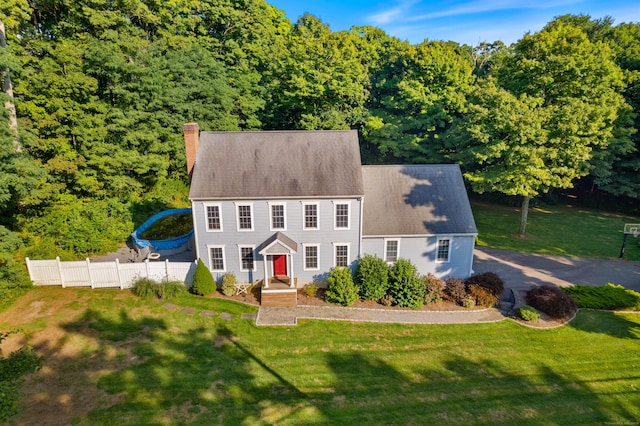 view of front of house with a front yard, fence, and a chimney