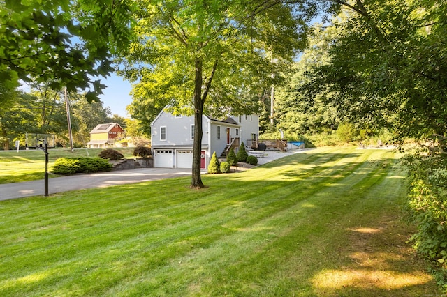 view of yard with driveway and an attached garage