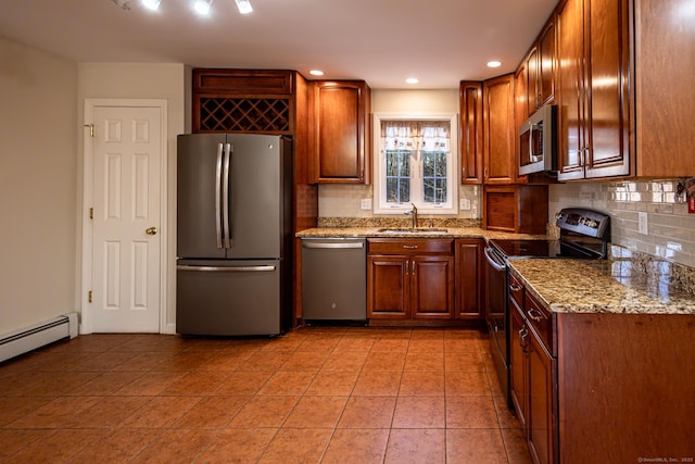 kitchen with light tile patterned floors, light stone countertops, stainless steel appliances, a sink, and decorative backsplash