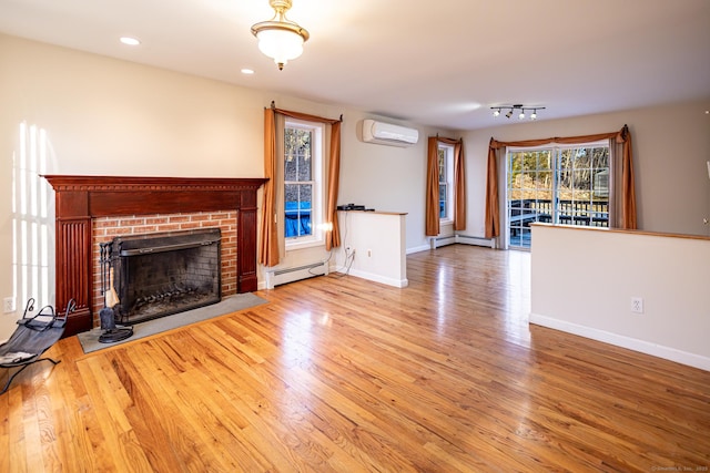 unfurnished living room with a wall unit AC, wood finished floors, baseboards, baseboard heating, and a brick fireplace