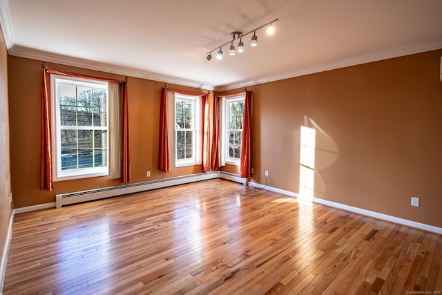 empty room featuring a baseboard heating unit, hardwood / wood-style floors, plenty of natural light, and ornamental molding