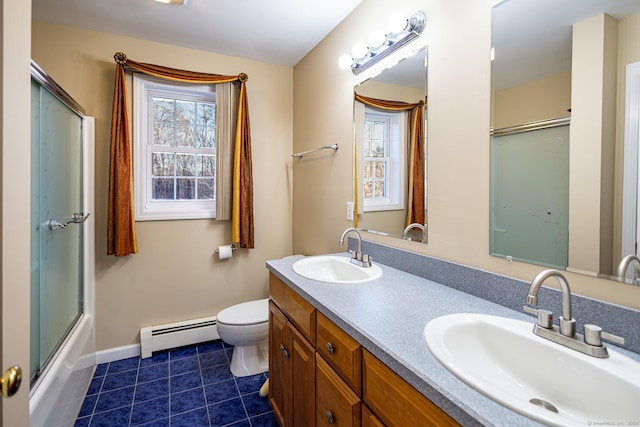 full bathroom with toilet, double vanity, baseboard heating, and a sink