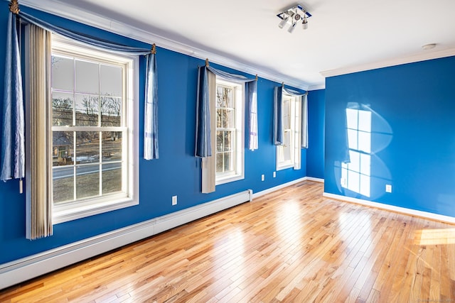 unfurnished room with baseboards, baseboard heating, hardwood / wood-style flooring, and crown molding