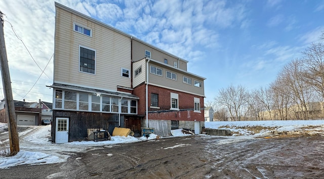 snow covered property featuring brick siding